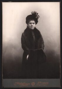 Постановочная фотография дамы в элегантной шляпе с муфтой в руках. Российская Империя.